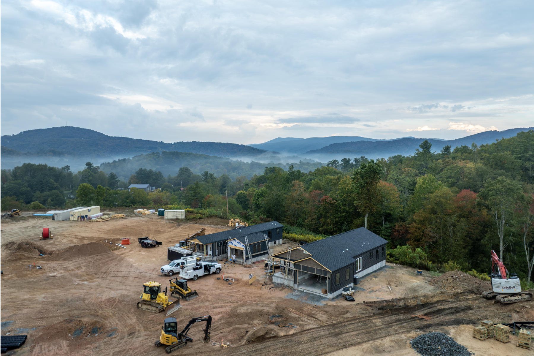 Aerial view of homes under construction at Blue Haven Avery, with misty Blue Ridge mountains behind