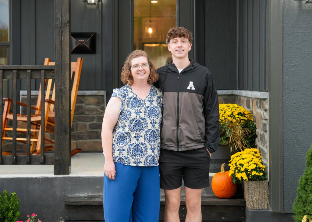 A Blue Haven resident and her son on the steps of their home